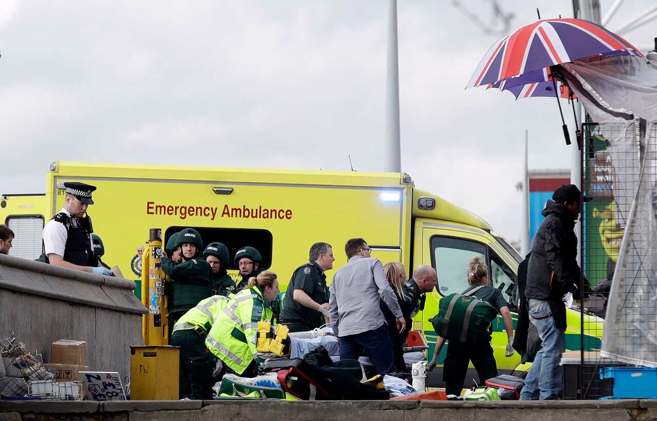 Emergency services staff provide medical attention close to the Houses of Parliament in London, Wednesday, March 22, 2017.
