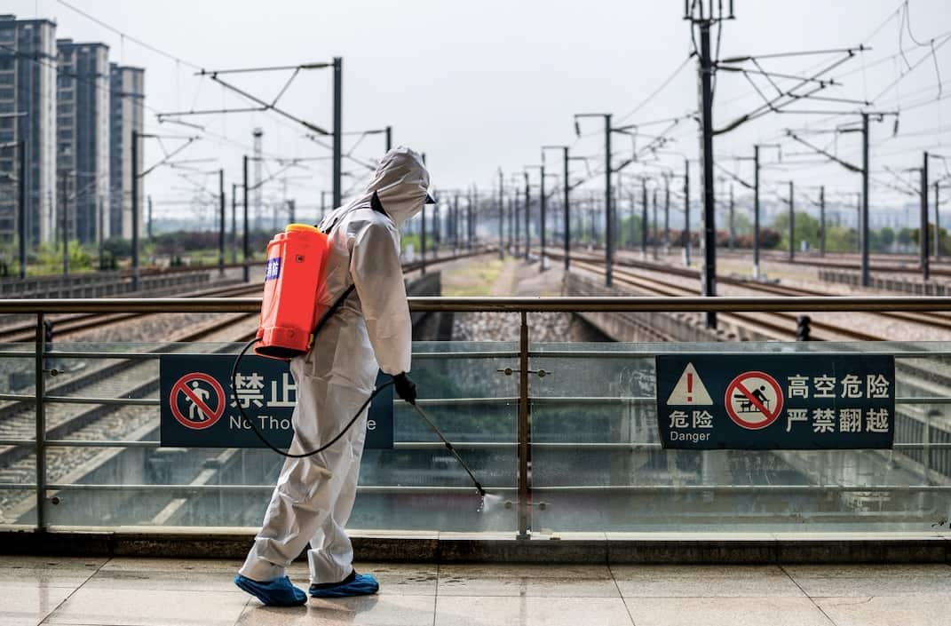 A staff member sprays disinfectant at Wuhan Railway Station.