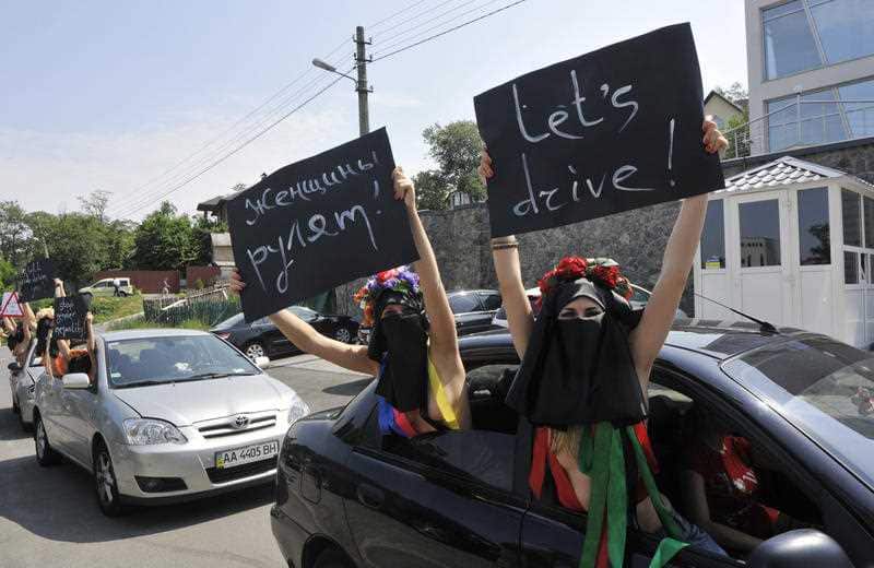 Semi naked activists from the Ukrainian female rights group Femen protest in front of the Saudi Arabian embassy against a ban on driving cars for women in Kiev, Ukraine, Thursday, June 16, 2011.