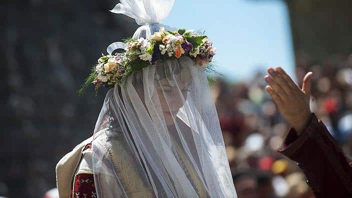 The bride rides a horse to the church during a traditional wedding ceremony in the village of Galicnik.