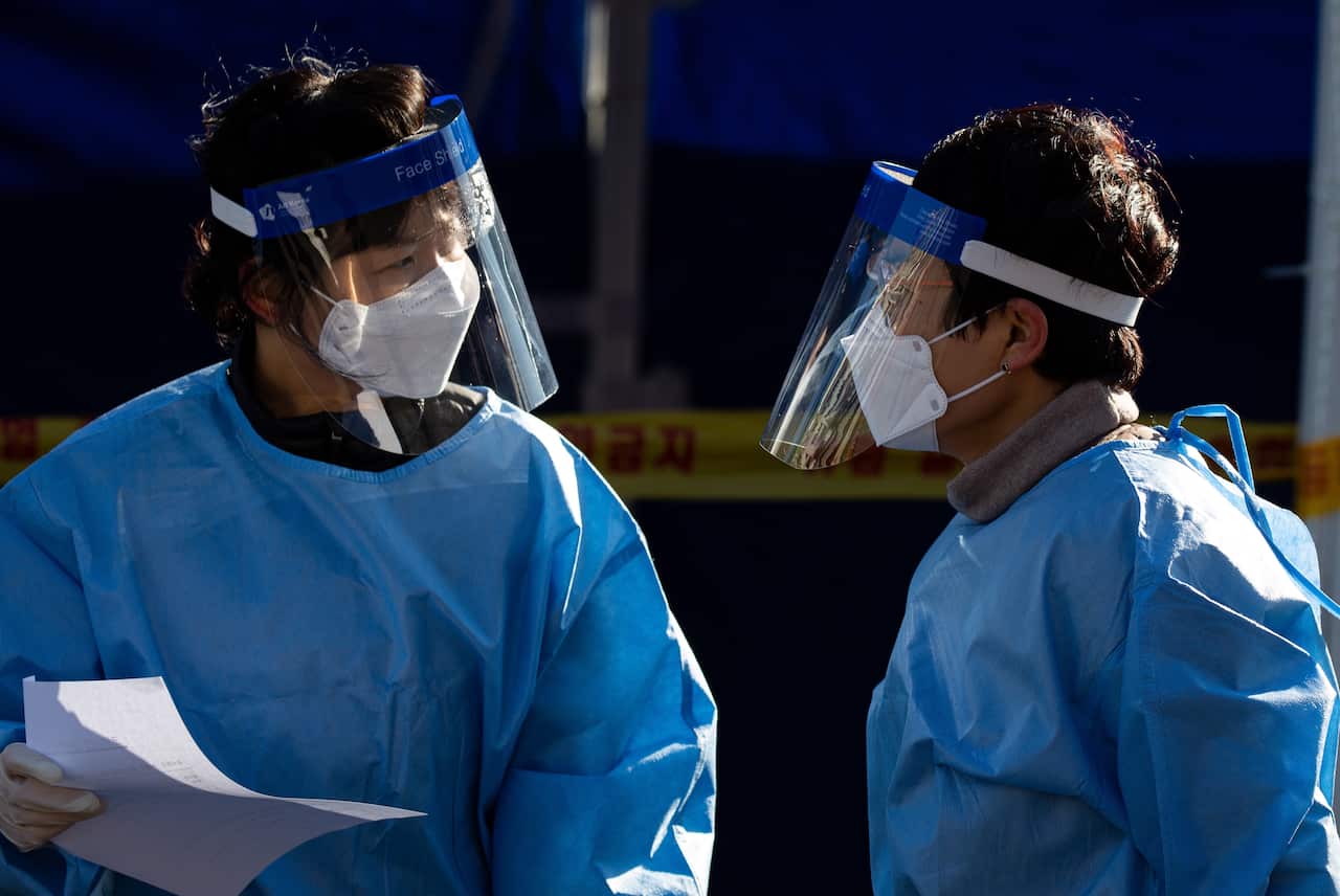 Health workers at a makeshift clinic testing for COVID-19 at Seoul Station in Seoul, South Korea, 14 December 2020. 
