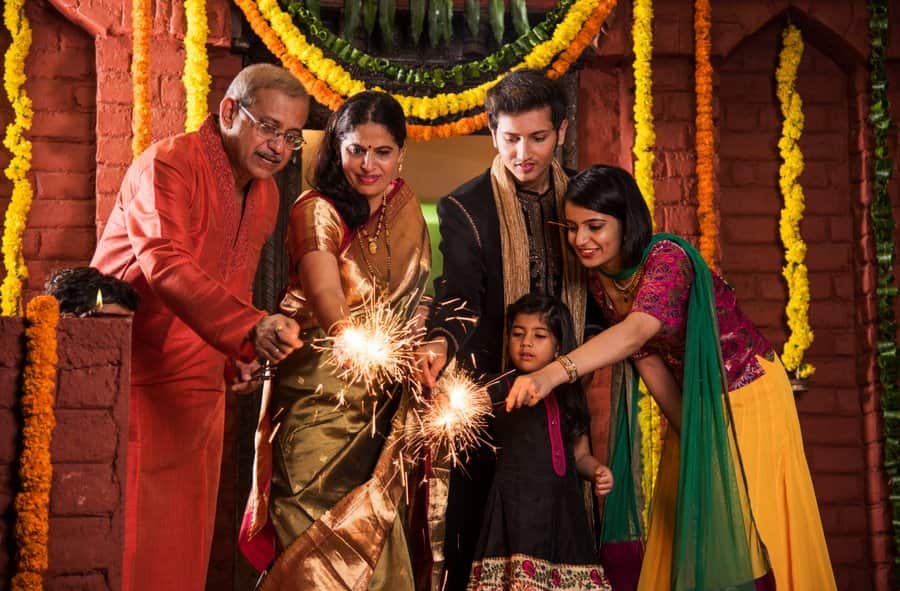 Indian Family celebrating Diwali festival with fire crackers