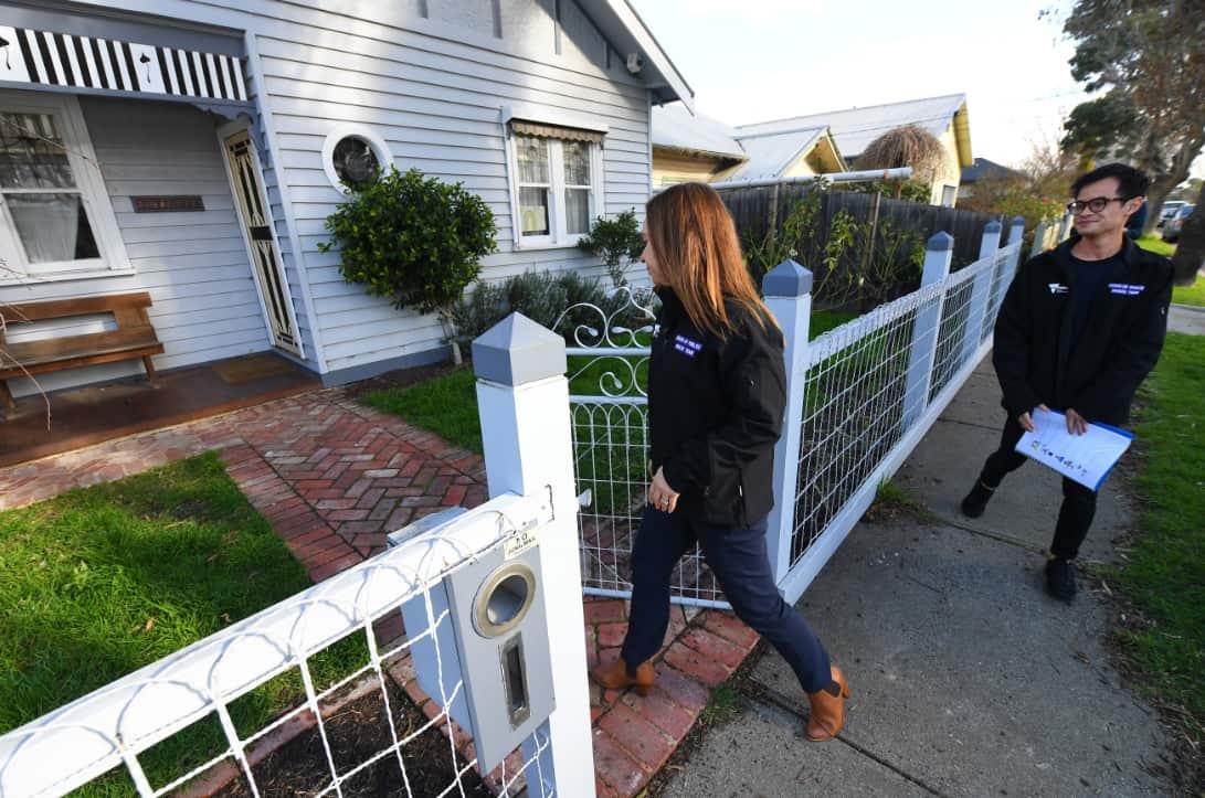 DHHS community engagement team members Sonia O'Neil (left) and Joey Nguyen arrive to a property in Sunshine, Melbourne,