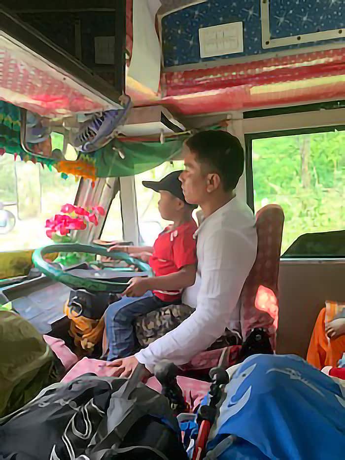 nepali bus driver with his kid in his lap as he drives from Pokhara
