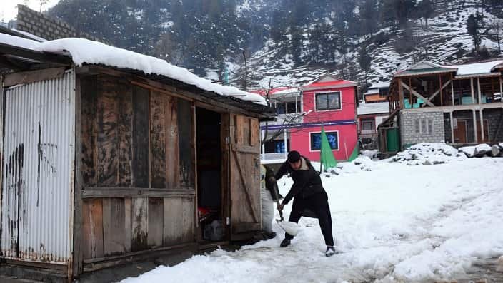 A Kashmiri removes snow outside his house after heavy snowfall in Keran, in Neelum Valley, Pakistan-administered Kashmir, Tuesday, Jan. 14, 2020.(AP Photo/M.D. Mughal)