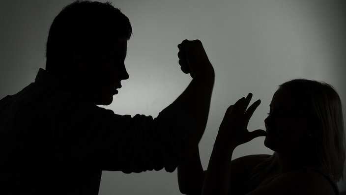 The illustration shows the silhouette of a man threatening a woman.