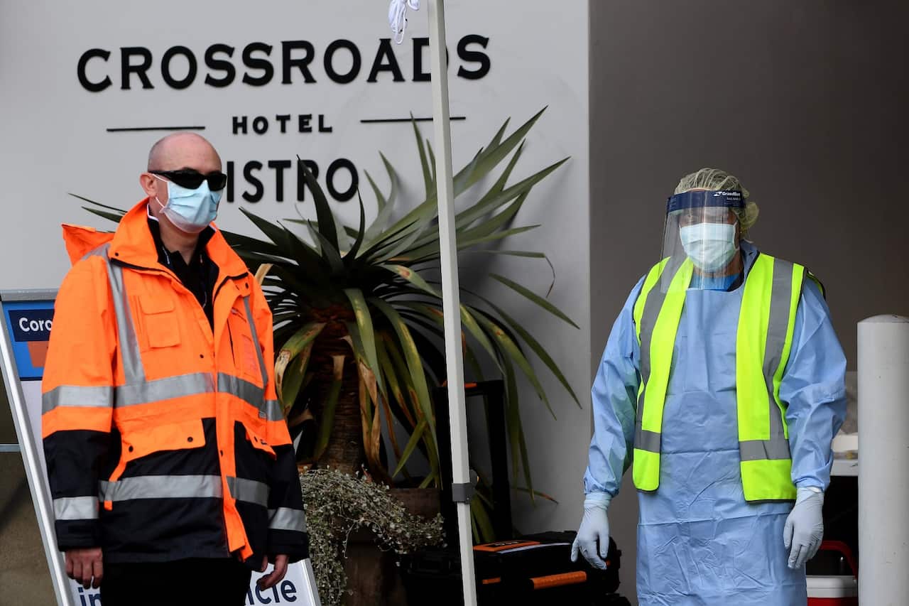 NSW Health workers and security dressed in Personal Protective Equipment are seen at the Crossroads Hotel testing centre in Sydney.