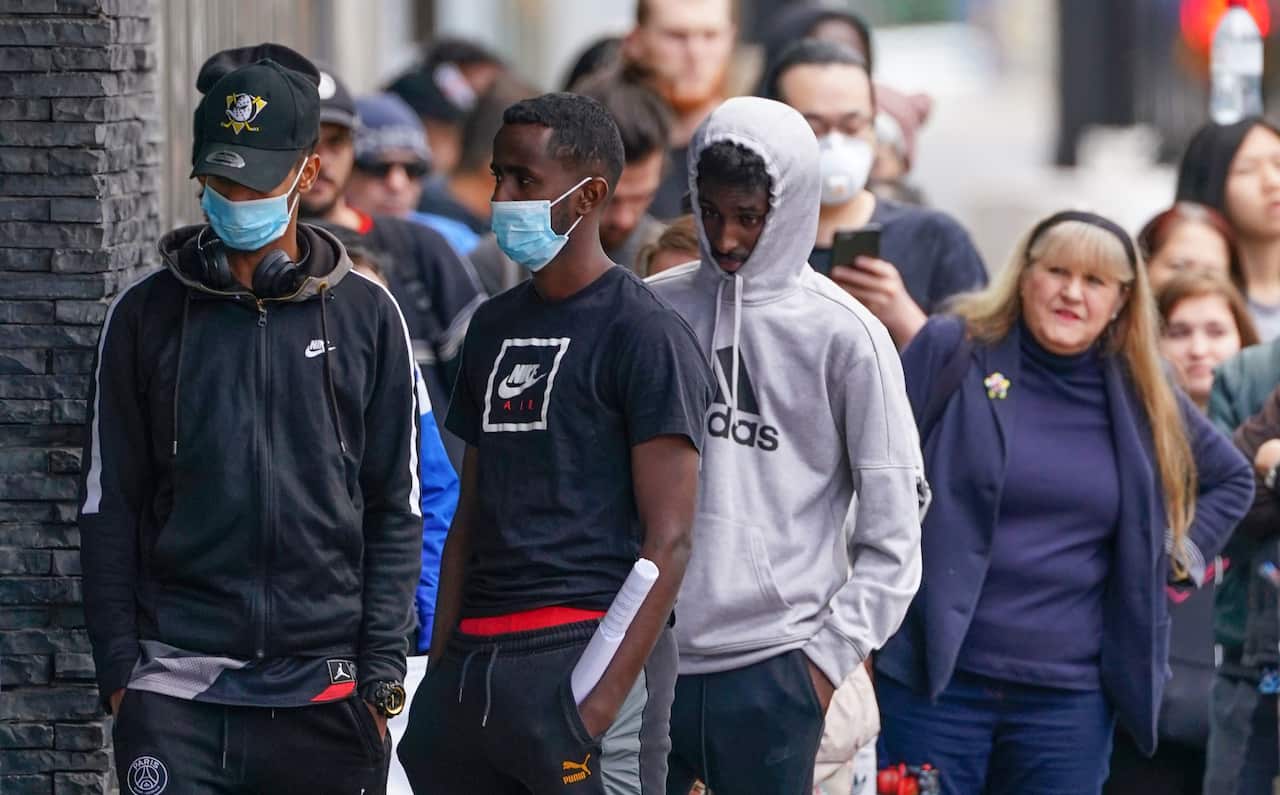 People are seen in long queue outside a Centrelink office in Abbotsford, Melbourne.