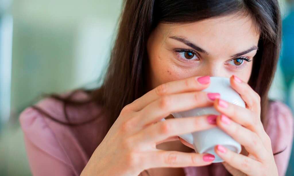 Young businesswoman having coffee in office