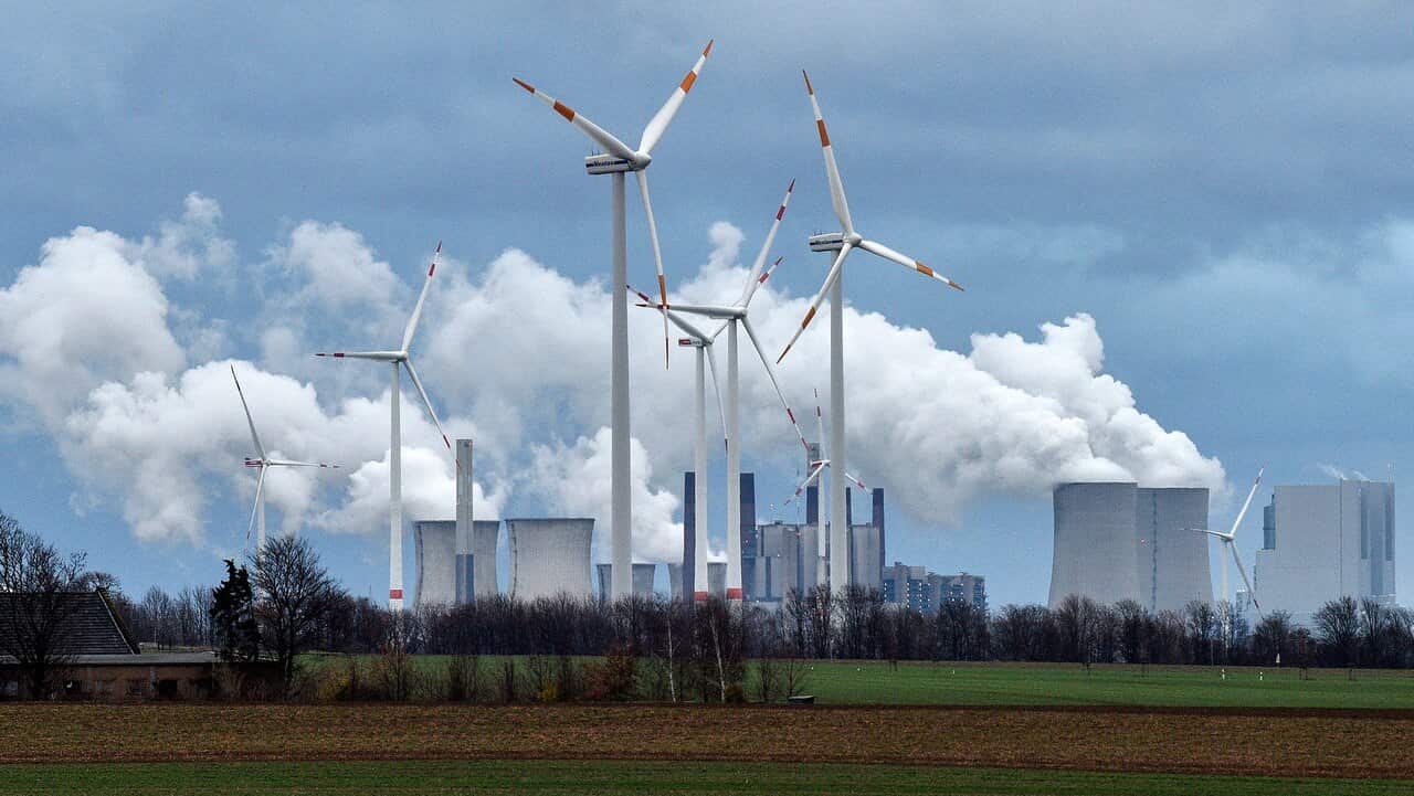 Renewable and fossil-fuel energy is produced with wind generators seen in front of a coal fired power plant near Jackerath, Germany.