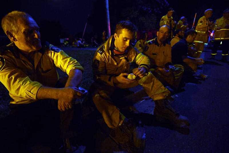 Weary firefighters take a break from battling bushfires in Nana Glen, near Coffs Harbour
