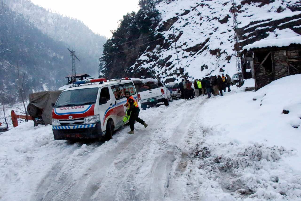 An ambulance, which heading to avalanches hit area, wait for road opening blocked by heavy snowfall, in Keran, in Neelum Valley.