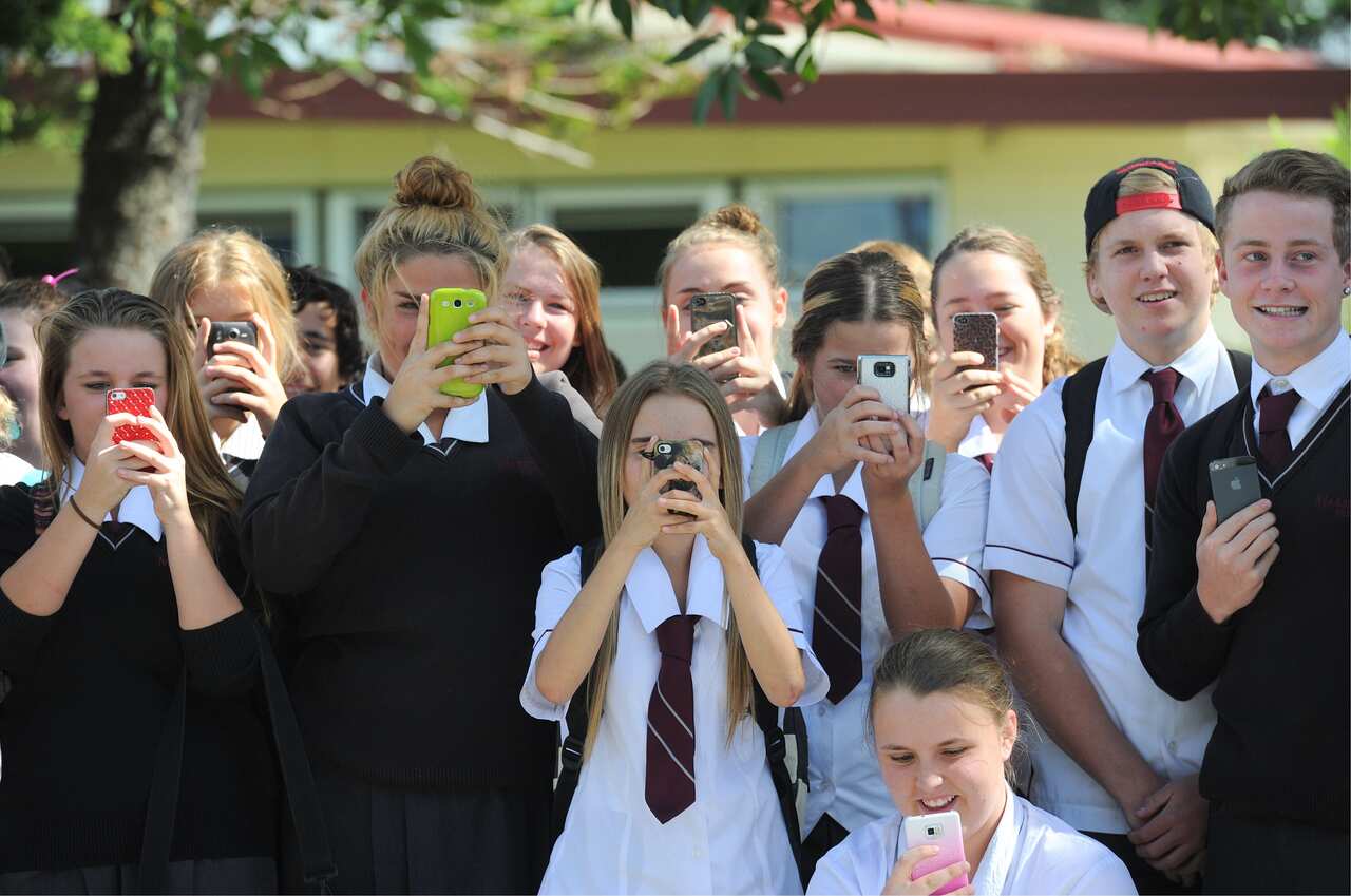Students take photographs on their phones at the Marsden State High School in 2013. 