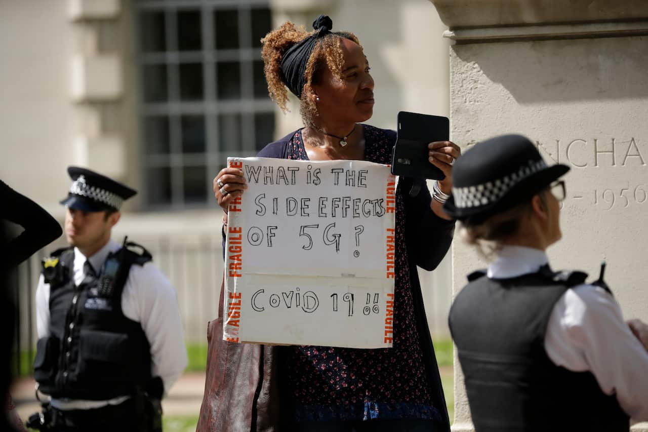 A woman holds up a placard at a coronavirus anti-lockdown, anti-vaccine, anti-5G and pro-freedom protest in London.