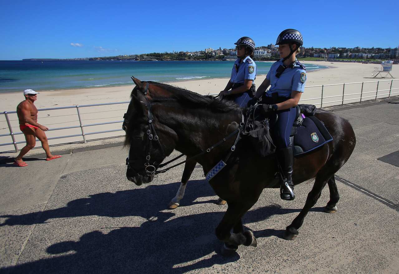 Police on horses enforce social distancing regulations at Bondi Beach.