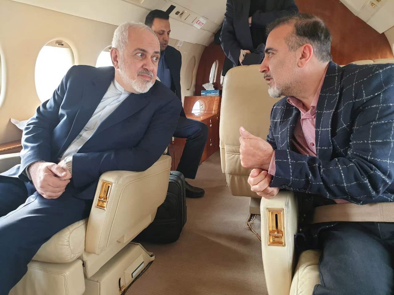 Iranian Foreign Affairs Minister Mohammad Javad Zarif (L) and Iranian researcher Masoud Soleimani sitting inside an airplane in Switzerland.