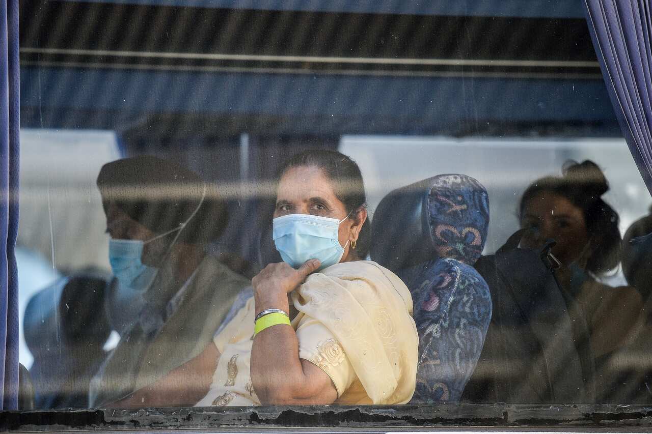 Travellers returning from India onboard a waiting bus to begin their 14-day imposed quarantine.