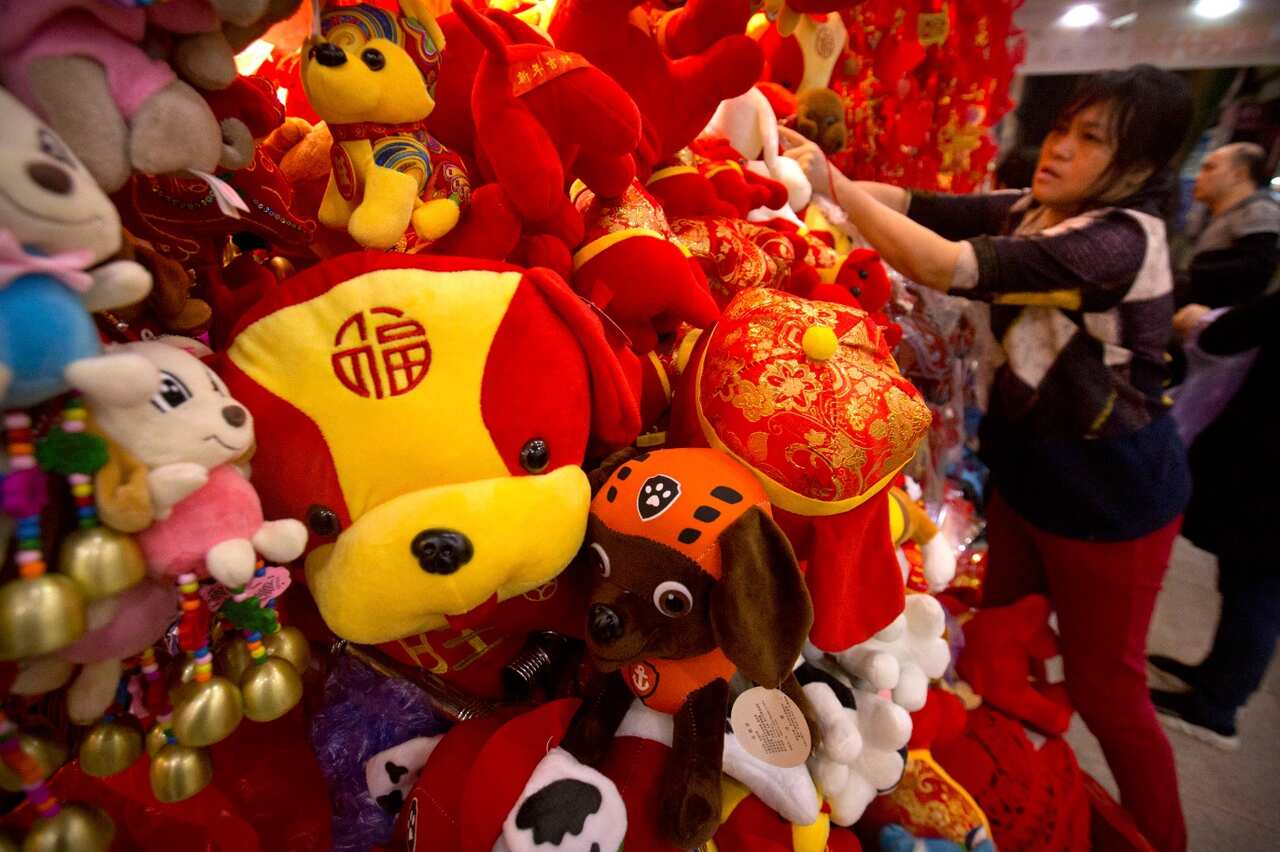 A vendor selling Lunar New Year decorations adjusts a display of stuffed animals at a wholesale market in Beijing, Tuesday, Feb. 13, 2018. 