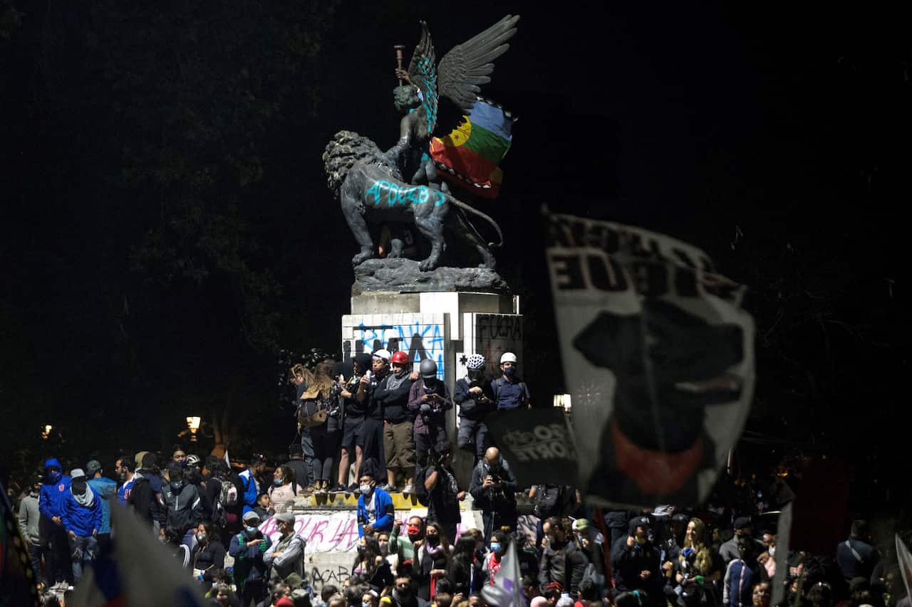 Chileans celebrate after learning about the partial results of the constitutional referendum in Santiago, Chile.