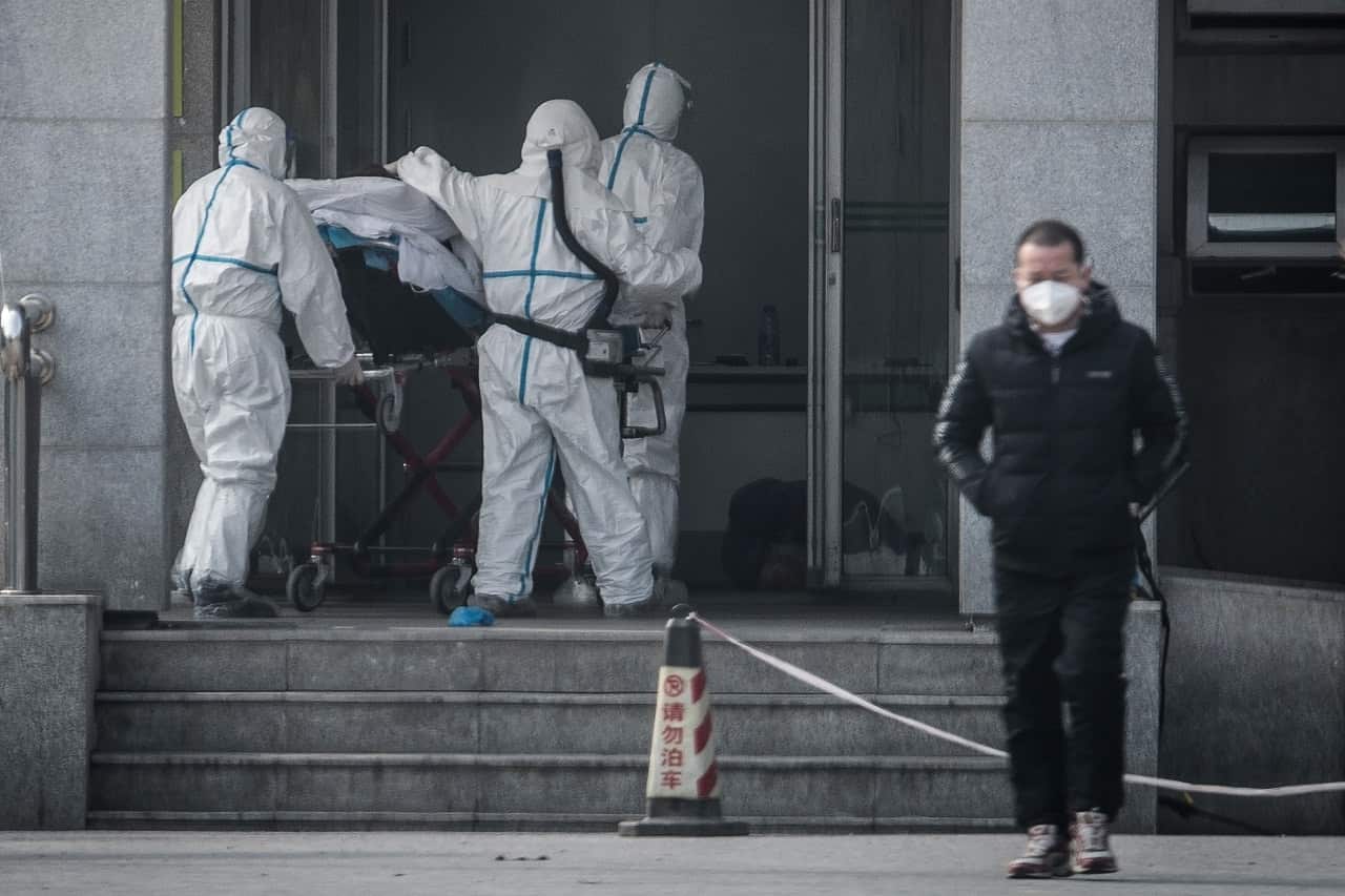 Medical staff members carry a patient into the Jinyintan hospital, where patients infected by the SARS-like virus are being treated