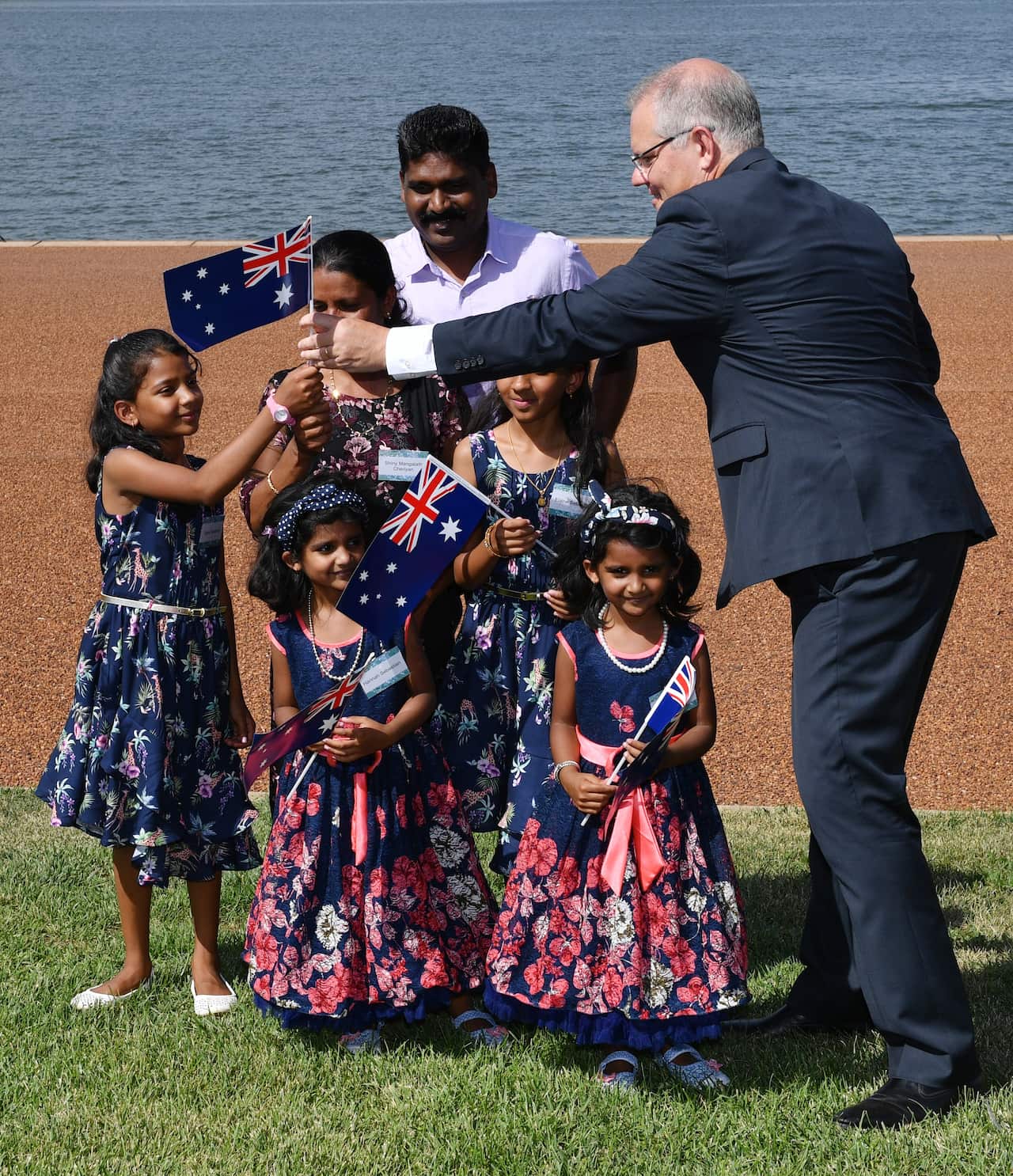 Prime Minister Scott Morrison hands out Australian flags to members of the Sebastien Family (originally from India).