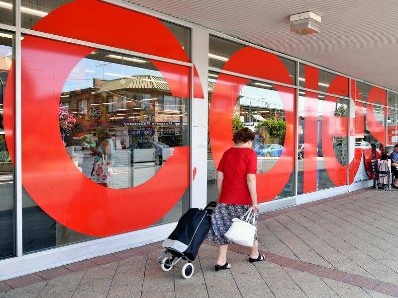 A shopper walks past a Coles supermarket in Sydney