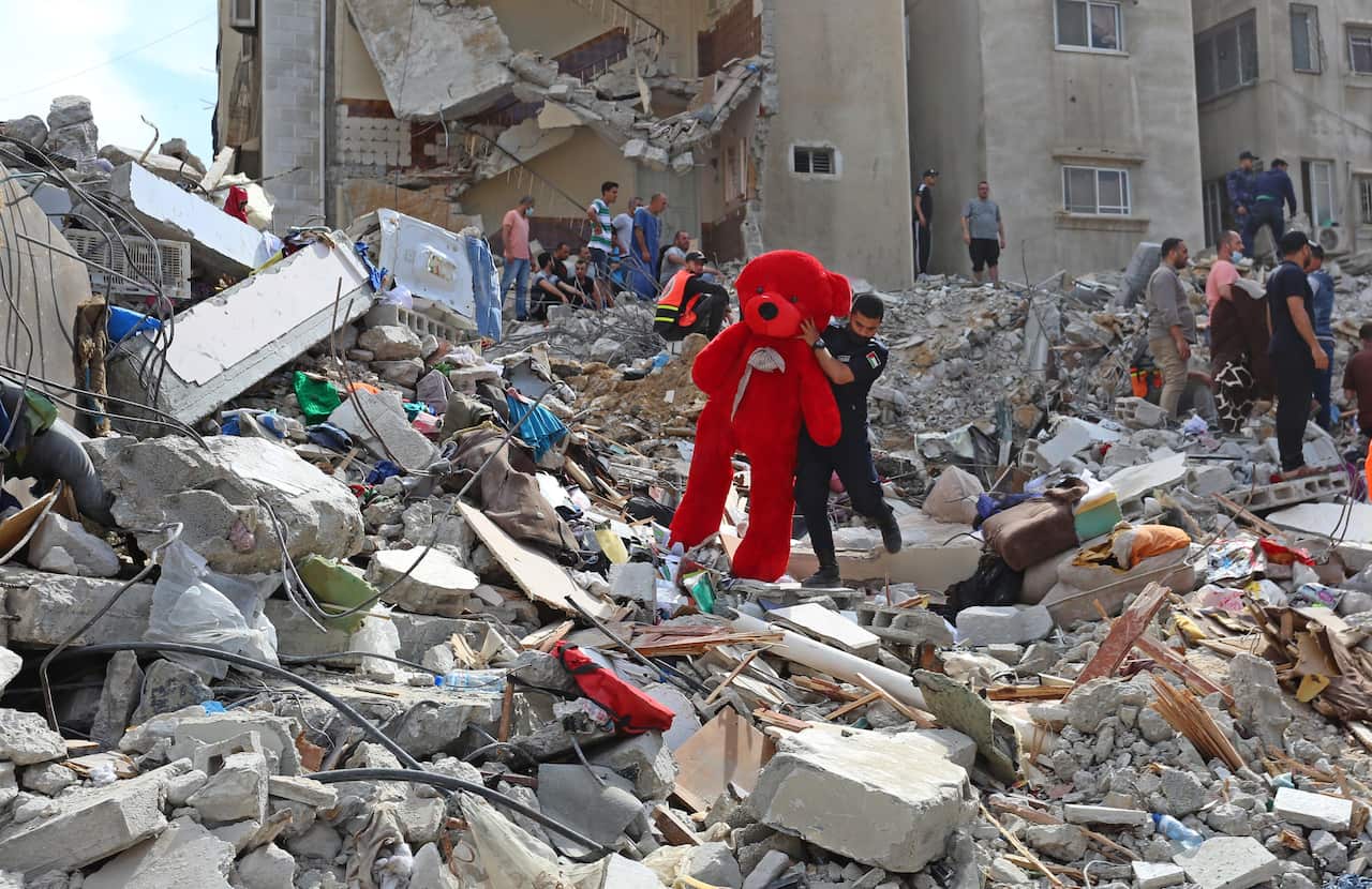 A teddy bear is removed from the debris after Israela airstrikes hit buildings in al-Rimal neighbourhood of Gaza City on 16 May, 2021. 
