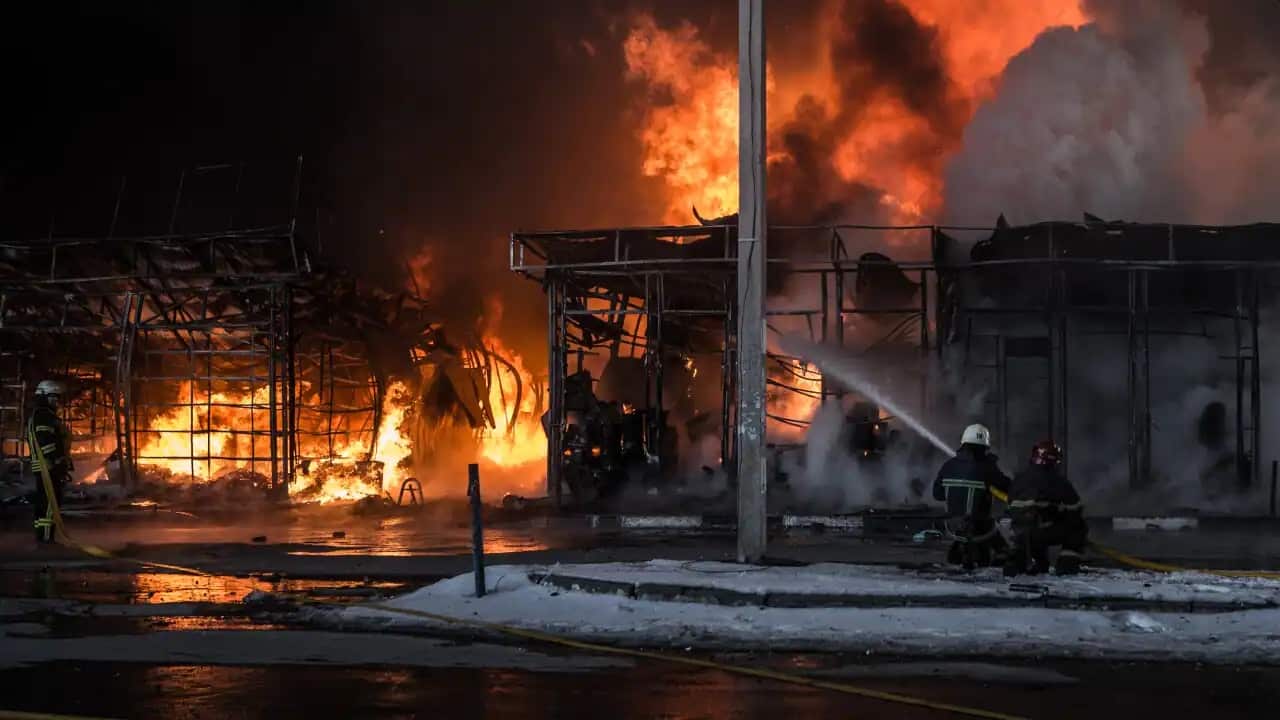 Firefighters try to extinguish a fire that broke out at the Saltivka construction market in Kharkiv, Ukraine, after it was attacked on 16 March, 2022.