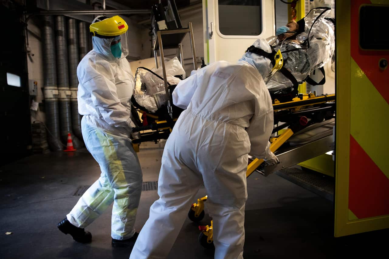 Medical staff transfer a COVID-19 patient into an ambulance at the CHR Citadelle hospital in Liege, Belgium, Wednesday, 21 October, 2020.