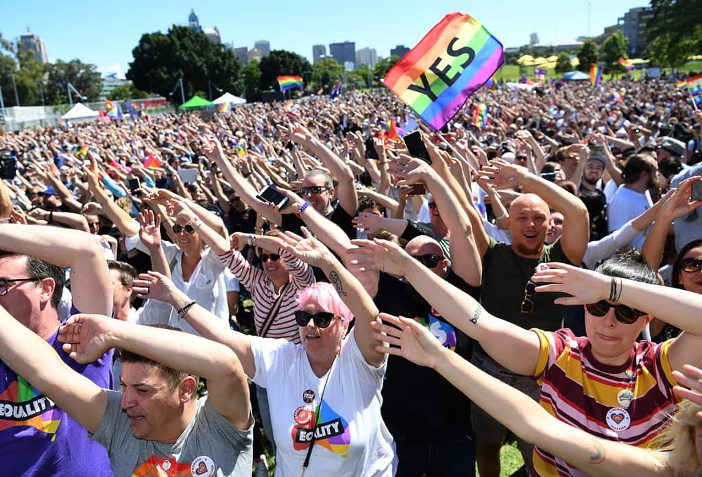 People celebrate after watching the same sex marriage vote result announcement during a picnic held by the Equality Campaign at Prince Regent Park in Sydney