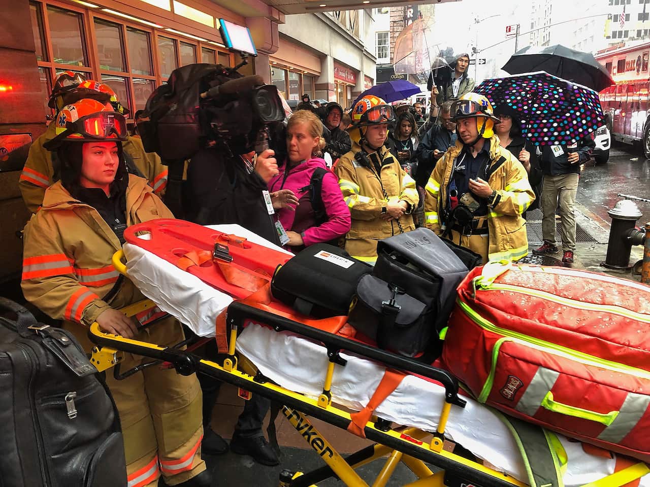 Firefighters prepare to bring a stretcher into a building.