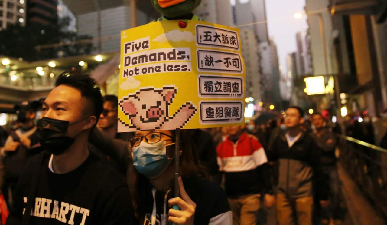 An anti-Hong Kong government protester holds a placard demanding five issues in Hong Kong on 8 December, 2019.