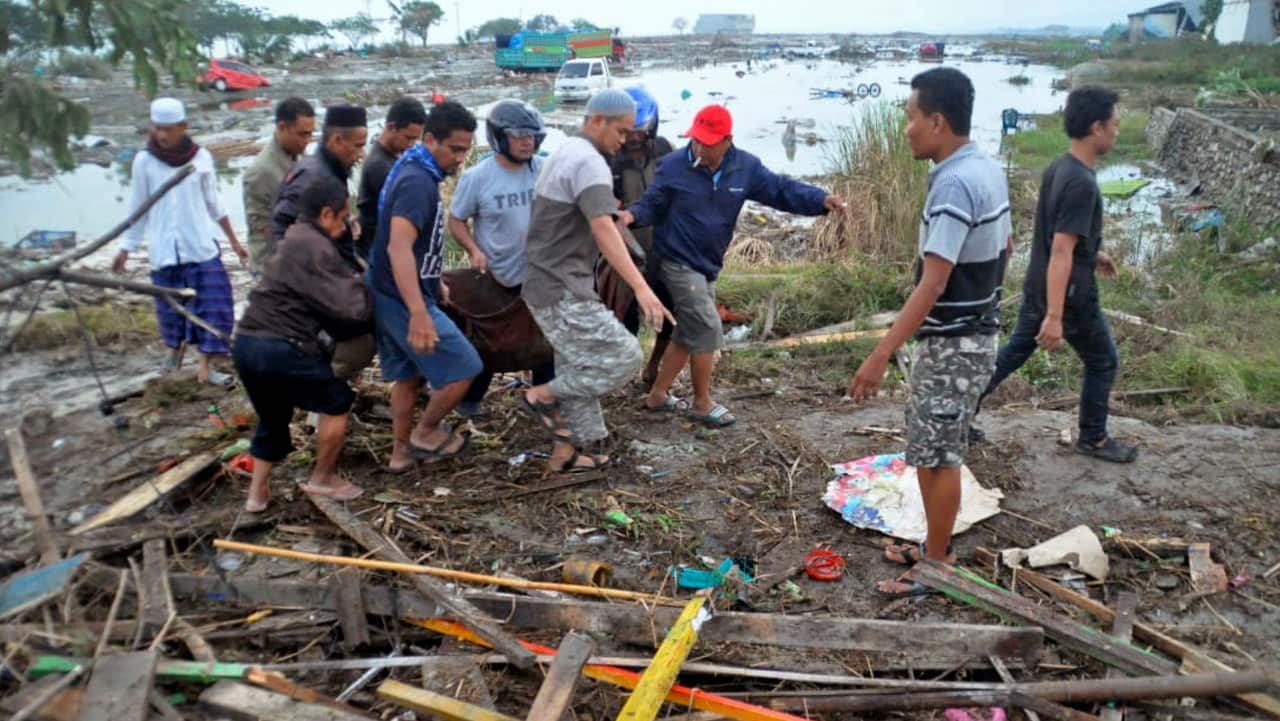 Residents carry a body bag containing the body of a tsunami victim in Palu, Central Sulawesi, Indonesia.