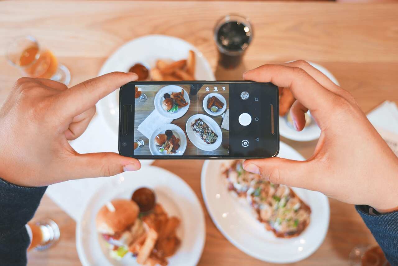 Sharing photos of food on social media.