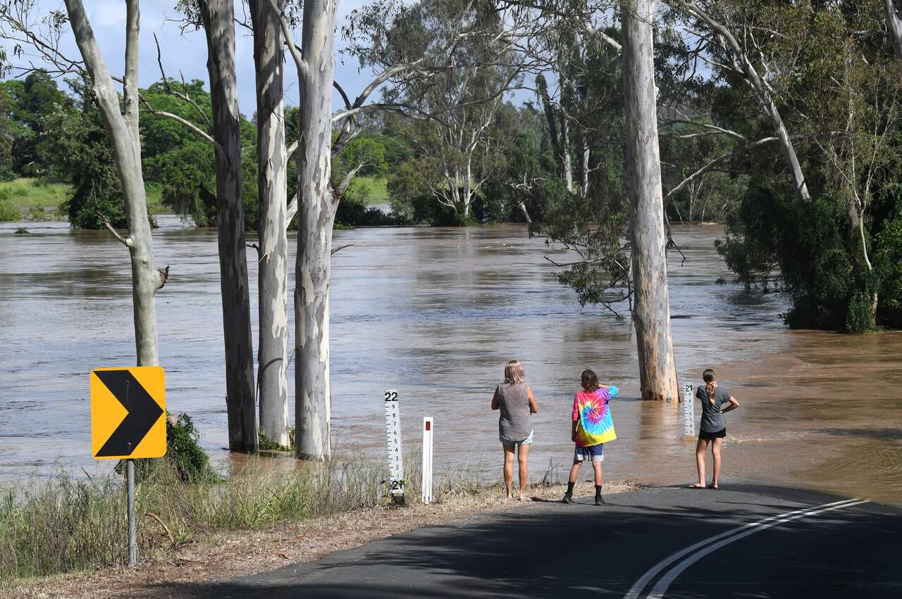 People are seen watching the flood waters from the Mary River rise in the town of Tiaro on 9 January. 