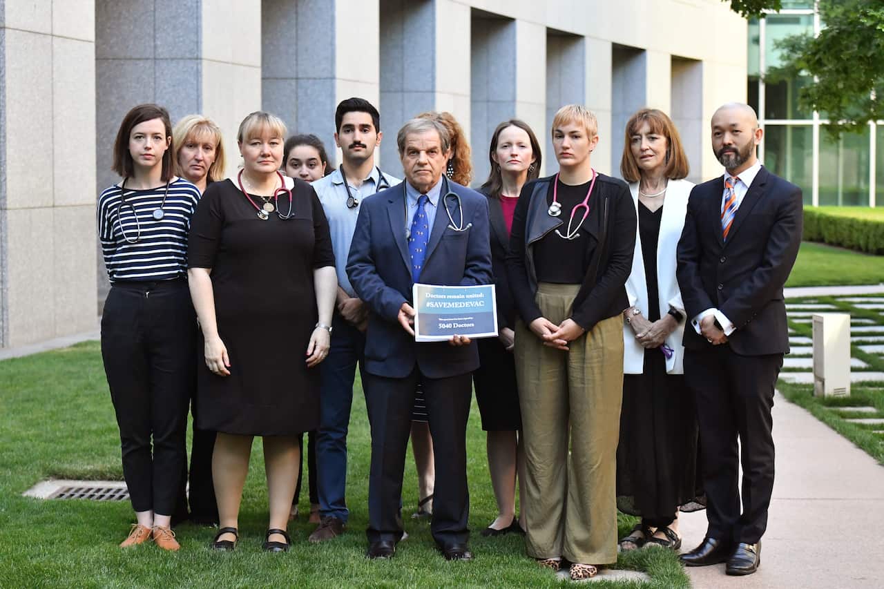 Paediatrician Professor David Isaacs (C) and 13 colleagues present an open letter signed by over 4,500 Australian doctors calling on Parliament to save medevac.