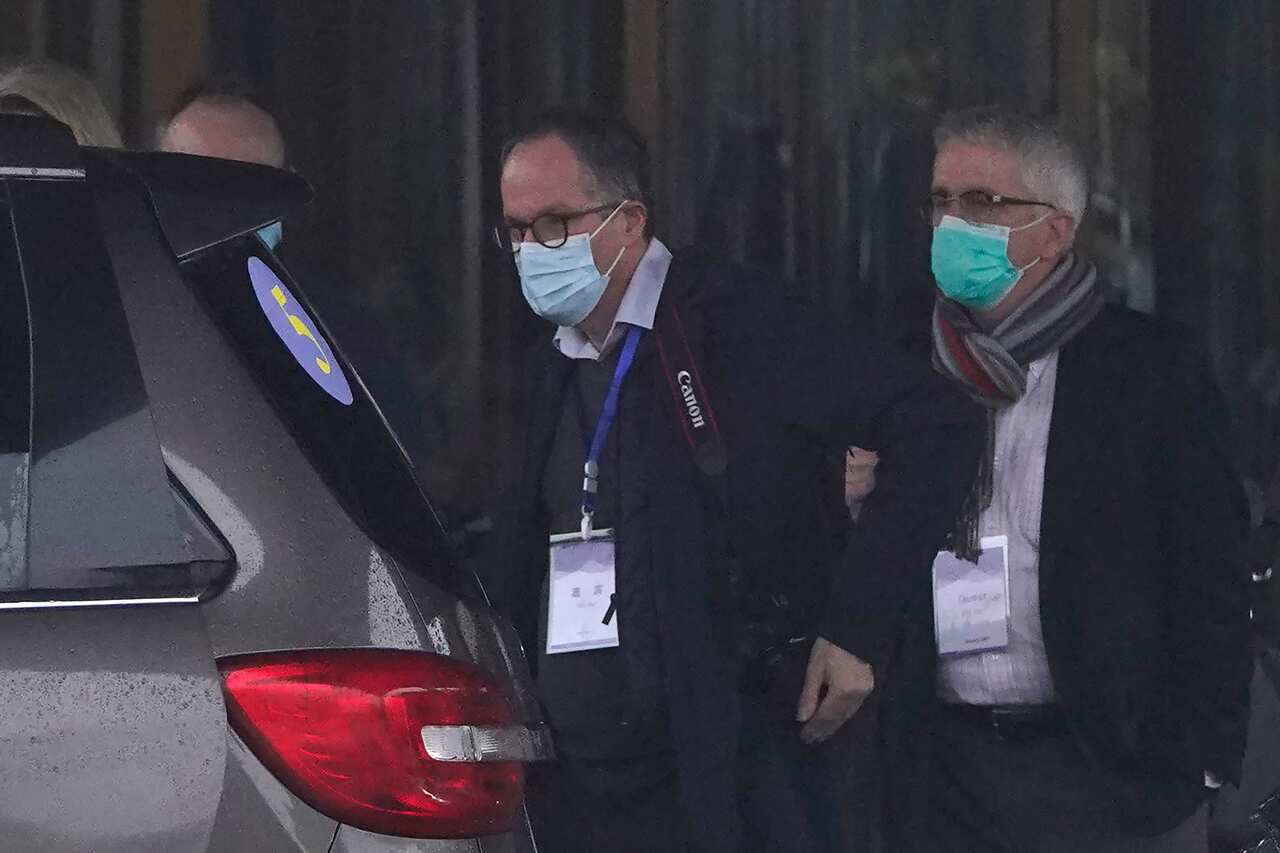Dominic Dwyer (R) and Peter Ben Embarek of the WHO team prepare to leave for a field visit from their hotel in Wuhan on 1 February, 2021.