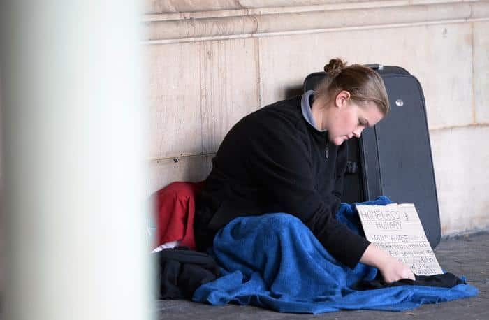 A homeless girl begs on a street in Sydney on May 12, 2014.
