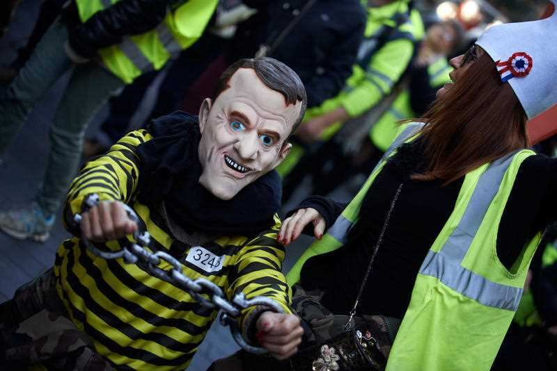 A 'Marianne' keeps a false Macron in chains amid the riots.