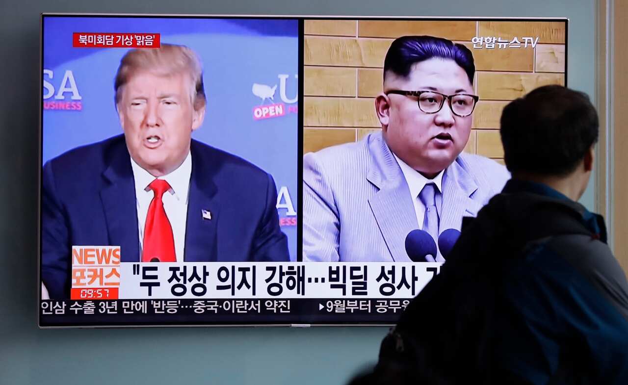 In this May 11, 2018, file photo, a man watches a TV screen showing file footage of U.S. President Donald Trump, left, and North Korean leader Kim Jong-un 