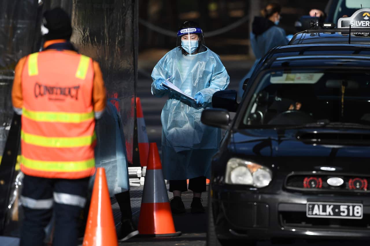 Healthcare workers are seen at a drive-through COVID-19 testing facility in Melbourne on 18 August. 