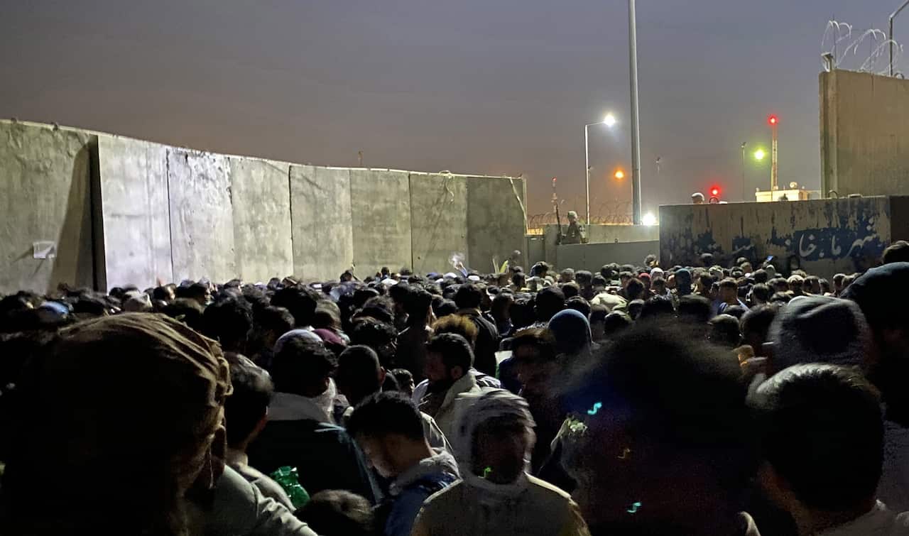 People struggle to get into the Hamid Karzai International Airport to flee Kabul, 23 August 2021