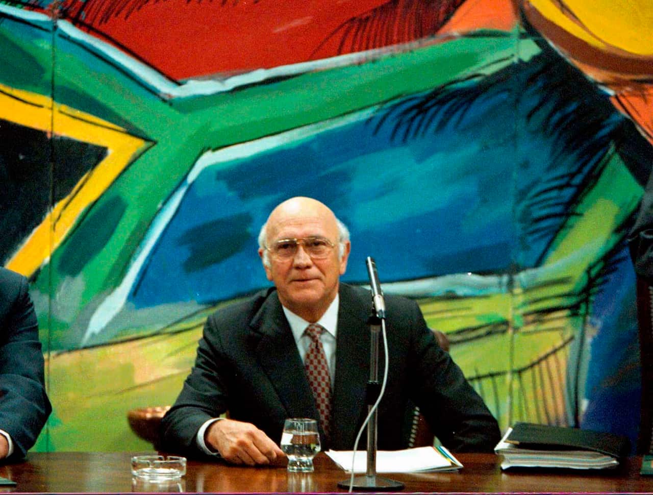FW de Klerk discusses his resignation below a mural of the new South African flag, Aug. 26 1997.