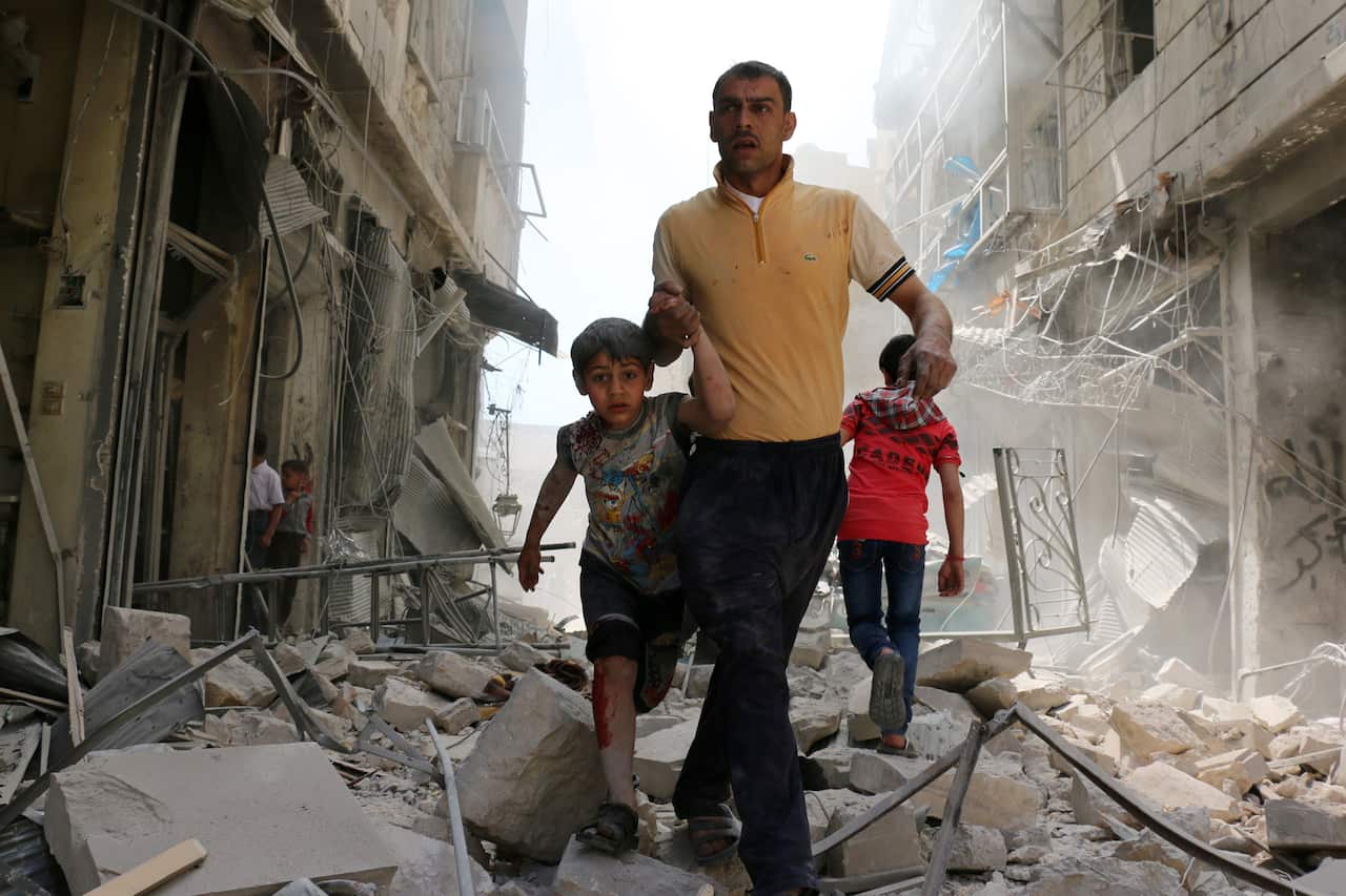 A Syrian man evacuates an area following a reported airstrike in the rebel-held neighborhood of Hayy Aqyul in Aleppo. 