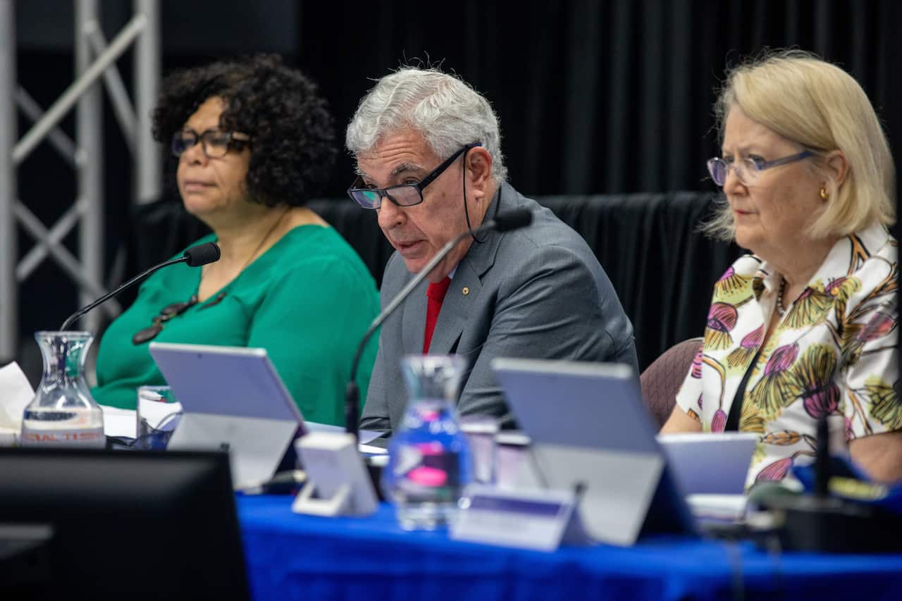 member of the Royal commission sitting at a table t