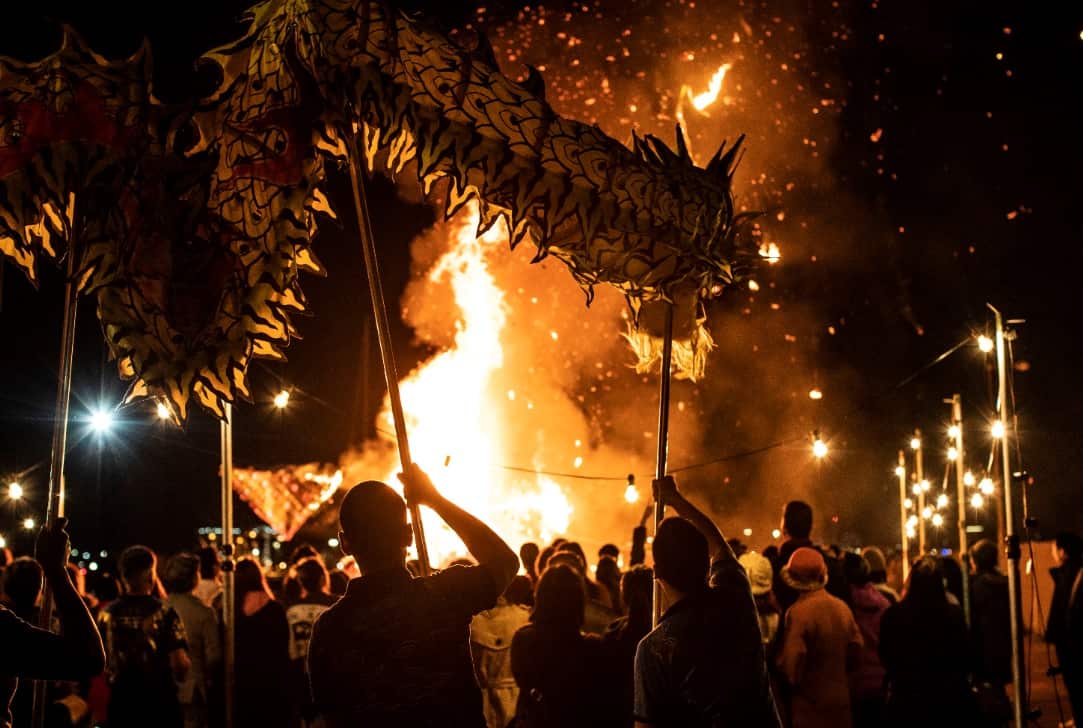 People watch as a hungry ghost effigy is burned.