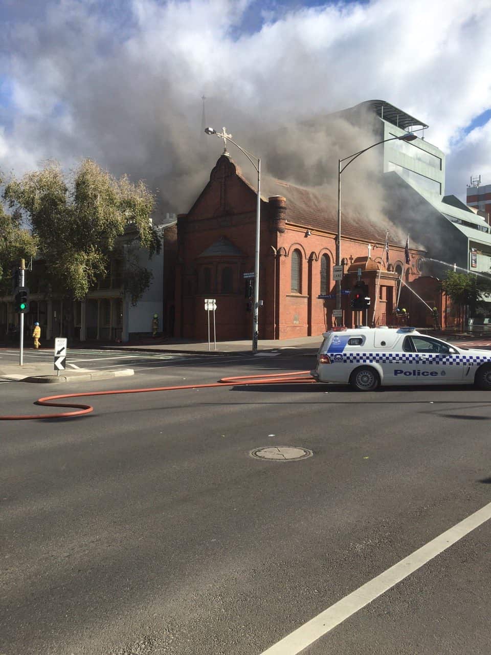 view of church on fire with police vehicle on site