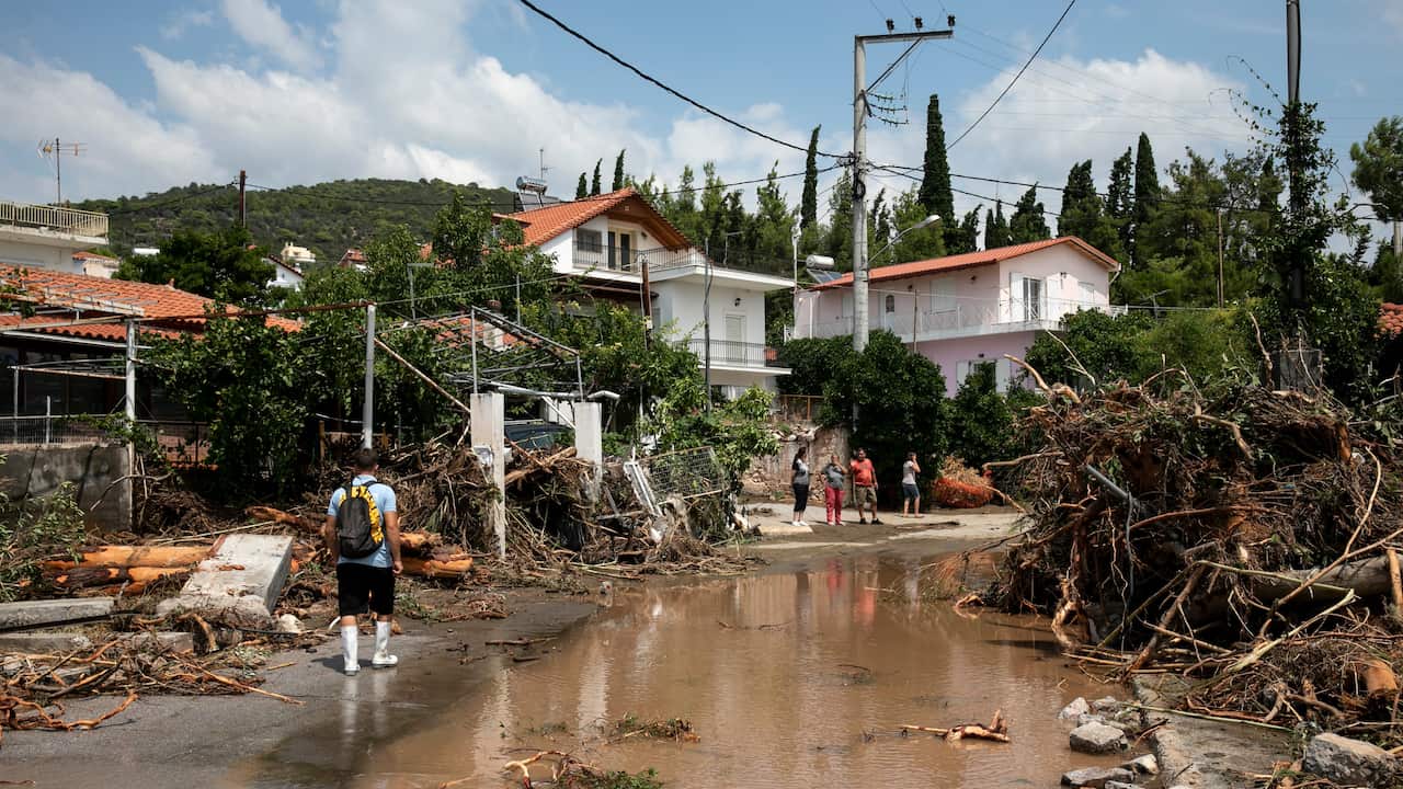 A man walks at a street full of debris following a storm at the village of Politika, on Evia island, northeast of Athens, on Sunday