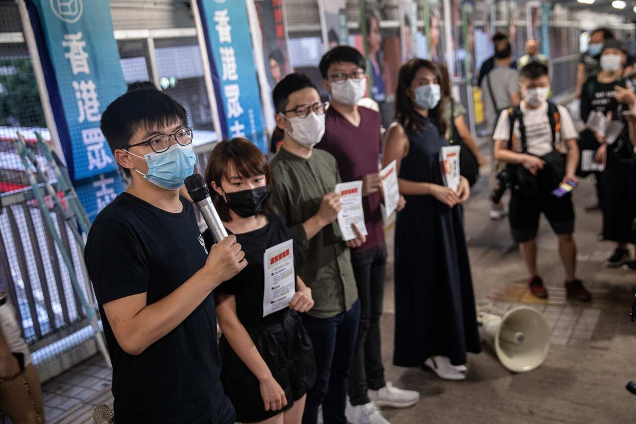 Pro-democracy activists and Demosisto members  all wearing face masks, distribute flyers against China's controversial national security law.
