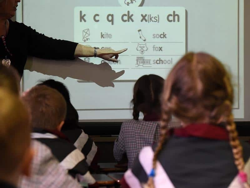 A file image of school students with their teacher in a classroom.